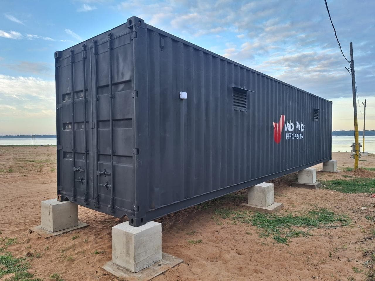 Contenedor equipado con la marca Valor Port sobre la costa del río